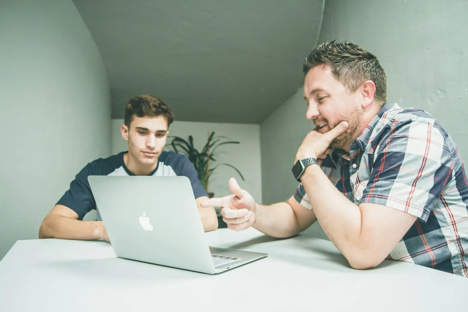 A tutor working one to one with a teenage student at a laptop